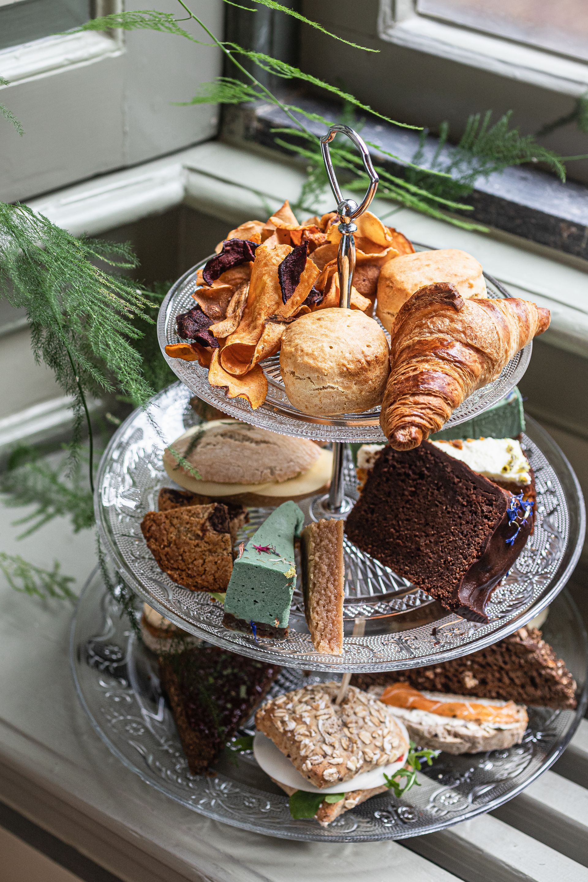 Etagère met vegan high tea: sandwiches, scones en gebak